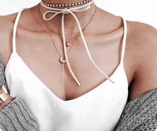 Layered necklaces on white top