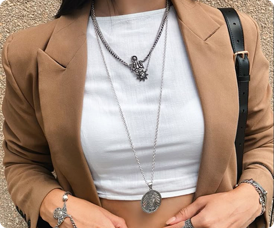 Layered necklaces on white top